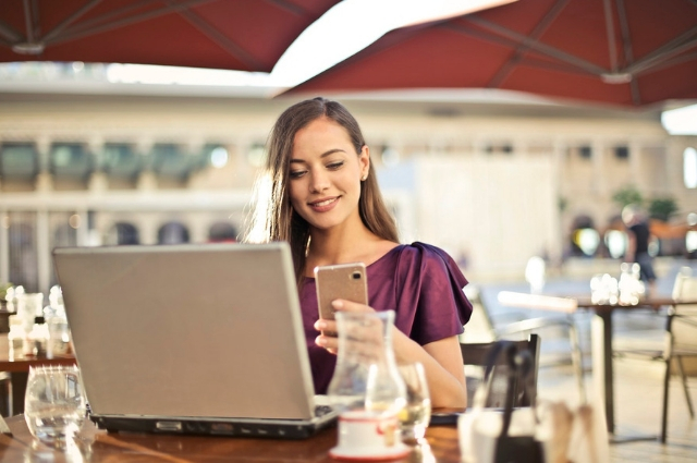 Picture of a business woman looking at her phone to check out daily quotes