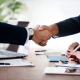 A picture showing two business people forming partnerships with a handshake