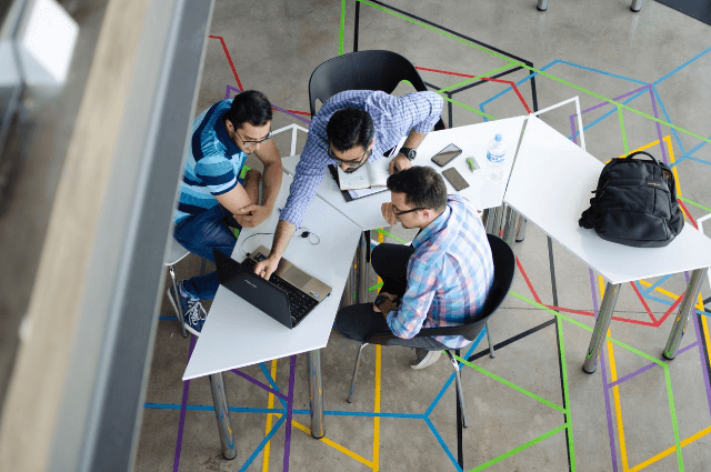 Image of three corporate business men working in a trendy office