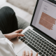An image of a woman typing her CV on a laptop