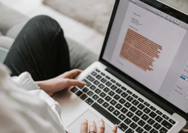 An image of a woman typing her CV on a laptop