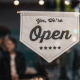 Picture of a shop saying we are open during return to the new normal of shopping locally at small businesses