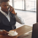 Picture of a man working from a serviced office with a laptop and a cup of tea whilst taking a call