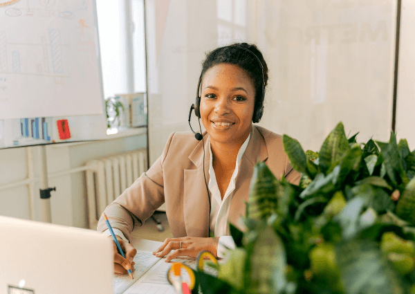 Picture of a female customer service rep on the phone and smiling