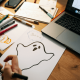 Image of a business man drawing a picture of a ghost for Halloween