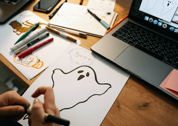 Image of a business man drawing a picture of a ghost for Halloween
