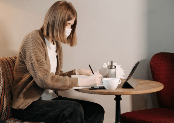 Image of a woman working with a mask and gloves in a COVID business world