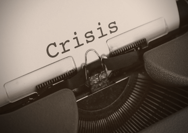 An image of an old vintage typewriter with written word crisis