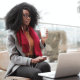 Business woman working outside with a laptop and coffee
