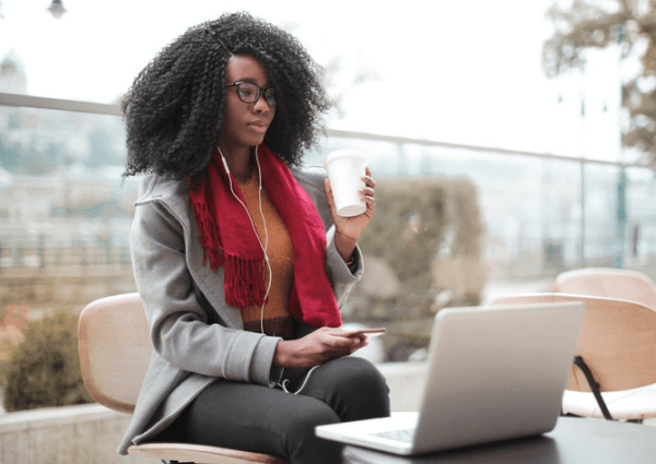 Business woman working outside with a laptop and coffee