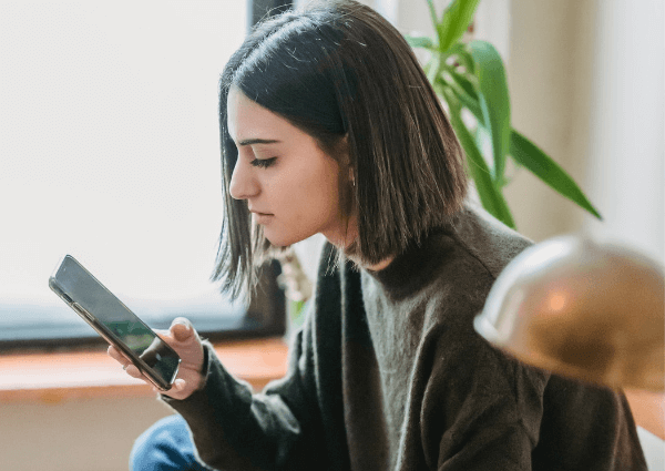 Image of a woman holding her phone checking social media