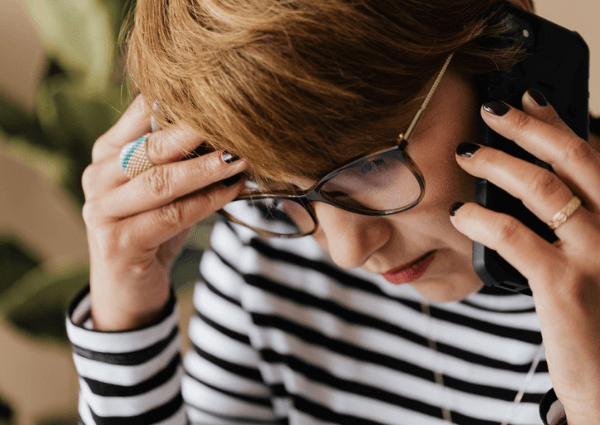 An image showing a business woman on the phone looking concerned