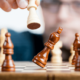 Picture of a chess board with pieces falling over to resemble risk management