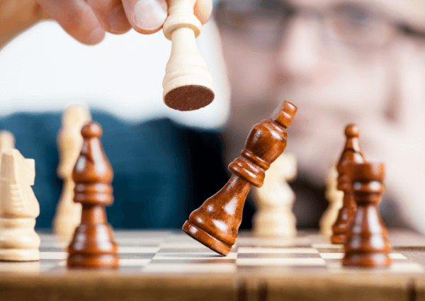 Picture of a chess board with pieces falling over to resemble risk management