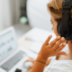 Small Business woman at her laptop wearing headphones answering customer queries