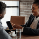 Business woman showing a digital business card on her phone to a customer