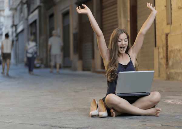 Picture of a business woman sitting on the floor of a road with her laptop