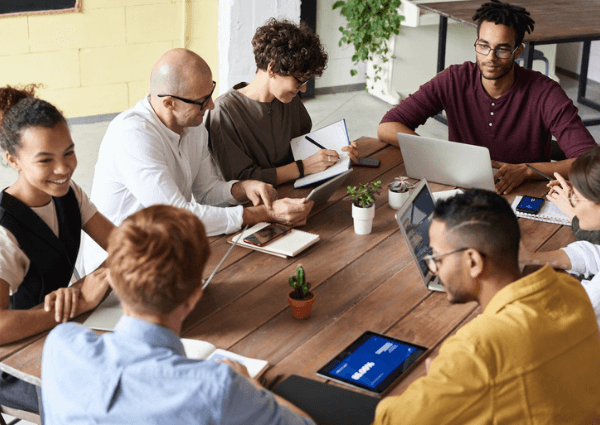 Picture of a team gathered around a table having a meeting