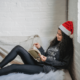 Image of a women relaxing reading a book in a santa hat