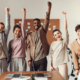 A business team standing with their arms in the air