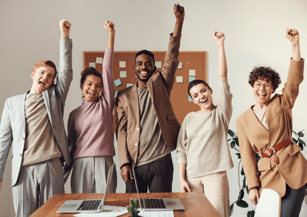 A business team standing with their arms in the air