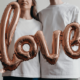 Picture of a man and a woman holding an inflated love balloon