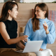 Two business women sitting down and talking