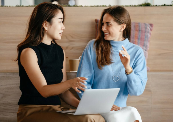 Two business women sitting down and talking