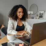 Business woman sitting at her laptop writing a blog