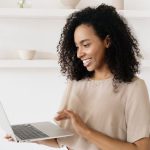 Business woman smiling while holding a laptop