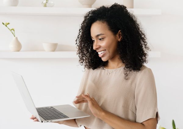 Business woman smiling while holding a laptop