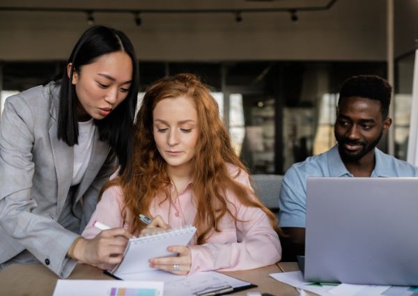 Three work colleagues sitting at a desk looking at a presentation