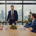 A business man having a meeting with his team around a board table in the office.